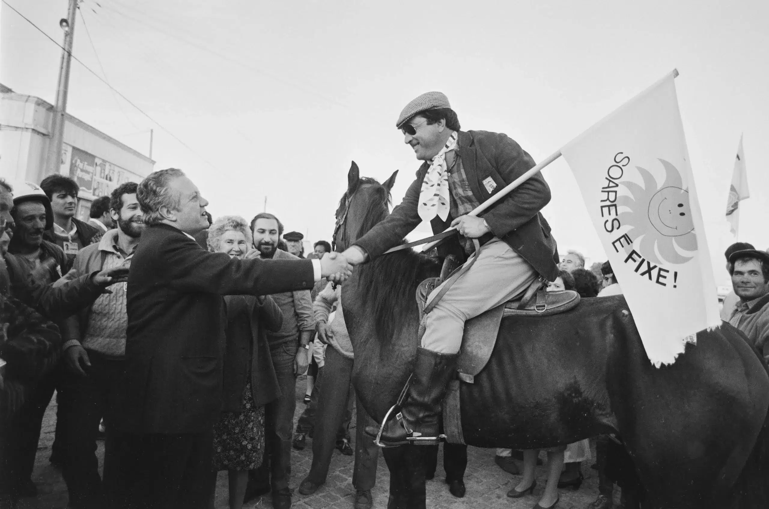 Mário Soares cumprimentado um apoiante montado num cavalo, com uma bandeira com o slogan 