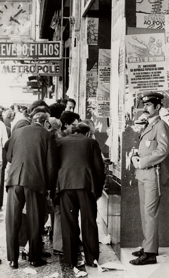 Pessoas a ler um jornal de parede, 4 de outubro de 1974. Fotografia de António Xavier; Armando Vidal; Carlos Gil. Fonte: ANTT, Flama