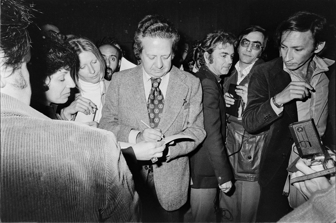 Mário Soares dando um autógrafo no centro de escrutínio da Fundação Calouste Gulbenkian, em Lisboa. Fotografia de Inácio Ludgero, 25 de abril de 1975. Fonte: Fundação Mário Soares e Maria Barroso, pasta 12278.055.102.